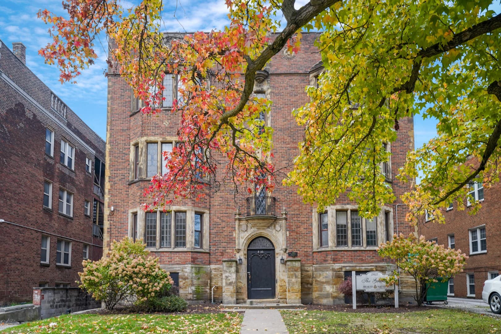Historic apartment entrance framed by autumn foliage